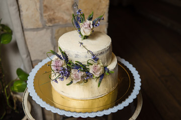 Elegant rustic wedding cake with flowers, close up of cake and blur background, selective focus