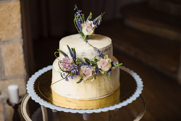 Elegant rustic wedding cake with flowers, close up of cake and blur background, selective focus