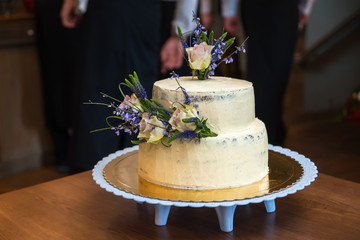 Elegant rustic wedding cake with flowers, close up of cake and blur background, selective focus