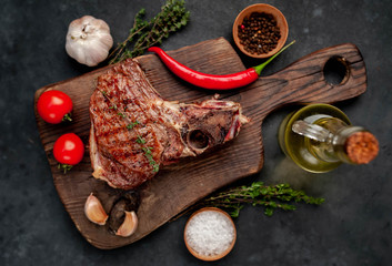 Fototapeta na wymiar grilled beef steak with spices on a cutting board on a stone background