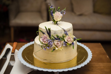 Elegant rustic wedding cake with flowers, close up of cake and blur background, selective focus
