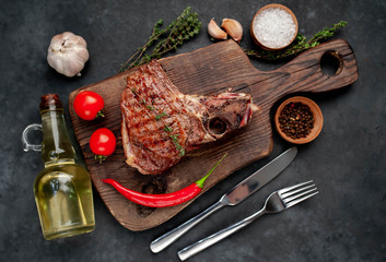 grilled beef steak with spices on a cutting board on a stone background
