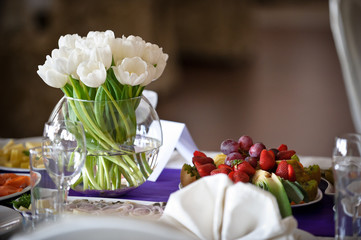 Beautiful fresh spring white tulips for Mother's Day in glass vase on a table. Wedding day, decoration