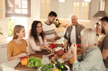 Happy people cooking food together in kitchen