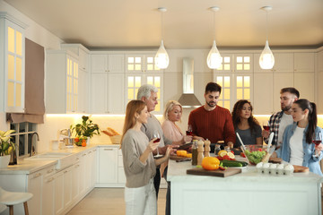Happy people cooking food together in kitchen