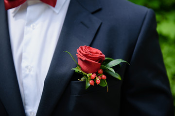 Red rose boutonniere in the pocket of the groom. The morning of the groom. Wedding preparation