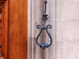 Close-up of traditional cast iron doorbell handle at the entrance wooden door