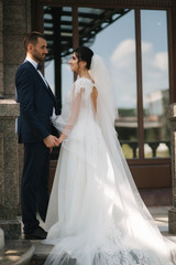 Wedding couple of groom and bride stand on balcony. Beautiful couple