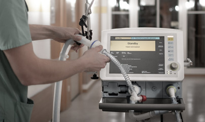 Nurse setting the pulmonary ventilator, medical machine used for patients with respiratory failure