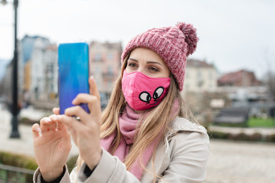 Woman wearing corona mask making selfie with phone
