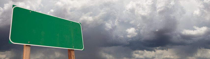 Blank Green Road Sign Against Ominous Cloudy Stormy Sky Background Banner © Andy Dean