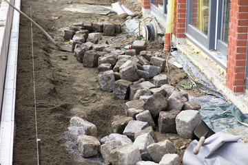 Construction site, crafts, road construction, pavement.Laying granite cubes on concrete