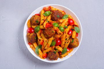 Italian penne pasta with meatballs and tomatoes