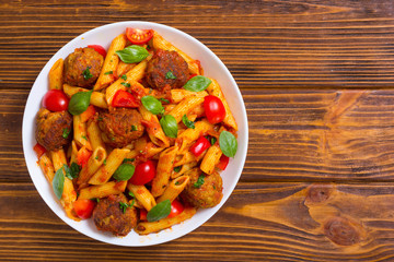 Italian penne pasta with meatballs and tomatoes