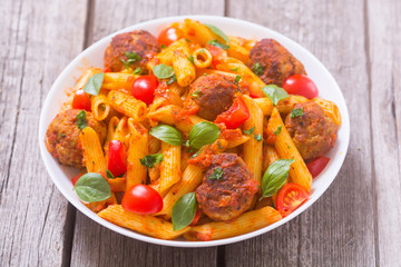 Italian penne pasta with meatballs and tomatoes