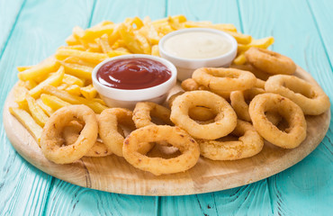 French fries and onion rings with sauces