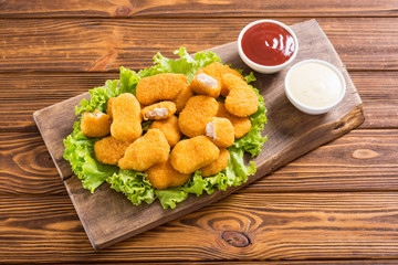 Chicken nuggets in plate on rustic background