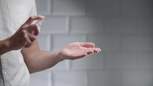 Man using hand sanitizer alcohol spray rub for hands hygiene in hospital for preventive coronavirus spread epidemic prevention.