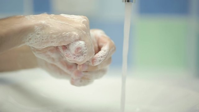 Closeup of man washing hands in slow motion - zoom out