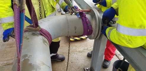 riggers move the pipe using two chain blocks