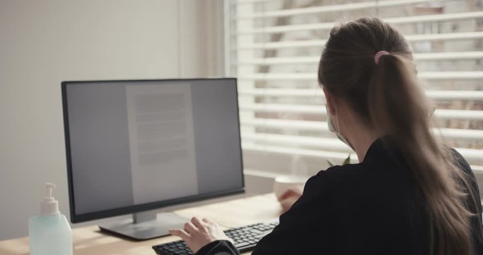 Woman work from home remotely face mask office coronavirus social distancing containment self isolate quarantine smartphone behind