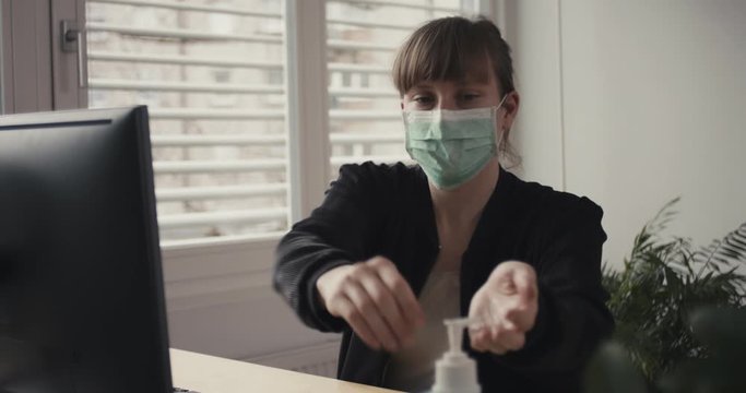 Woman put on face mask disinfectant work from home remotely office coronavirus social distancing containment self isolate quarantine