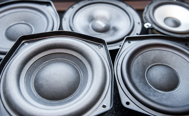 Multiple speakers with black and white membrane on table in workshop