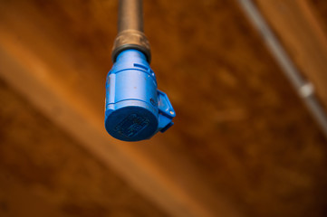 Eclectric plug hanging from ceiling in workshop