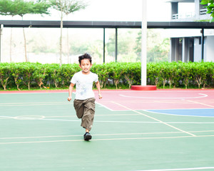 Obraz premium Boy running at the basketball court, being active and cheerful.