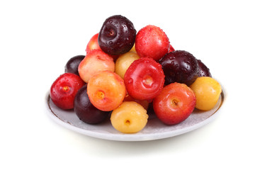 Different color cherries on dish