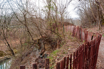 A fence along an eroded part of the Braddock Trail in Frick Park on a winter day, Pittsburgh, Pennsylvania, USA