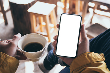 Mockup image blank white screen cell phone.man hand holding texting using mobile on desk at coffee shop.background empty space for advertise text.people contact marketing business,technology