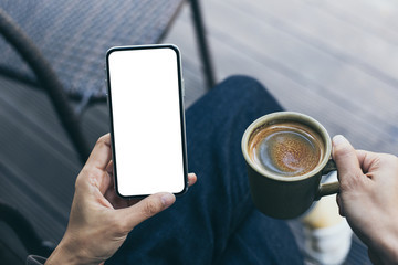 Mockup image blank white screen cell phone.woman hand holding texting using mobile on desk at coffee shop.background empty space for advertise text.people contact marketing business,technology