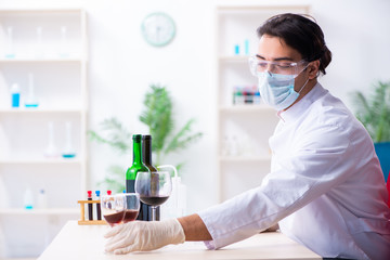 Male chemist examining wine samples at lab