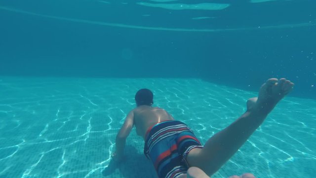 Child swimming underwater in the pool