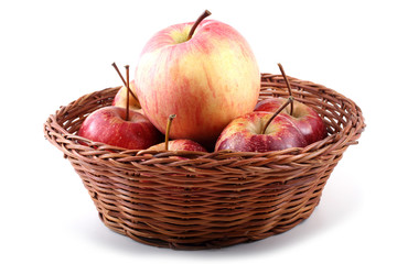 Big and little apples on wicker plate
