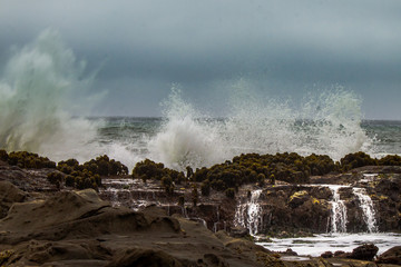 Waves crashing over rocks on the California coast.