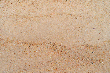 Fototapeta na wymiar Brown sand texture background from fine sand with natural line wave on it.