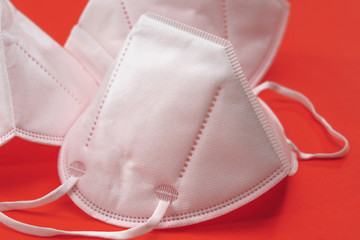 White protective medical masks on red background with copy space. Prevention of the spread of virus...