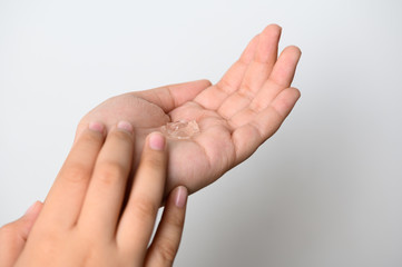 Hands Applying Sanitizer Gel. hands using wash hand sanitizer gel dispenser, against Novel...
