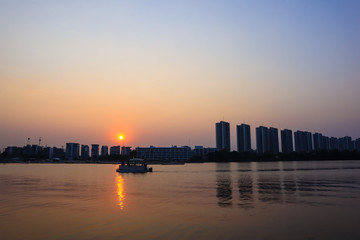 Fototapeta premium CItyscape modern apartment building near a lake under sunset twilight with cloud sky background with water reflections for background.