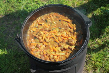Uzbek pilaf cooked in a cauldron in nature