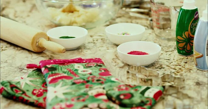 Cookie and baking mix for cookies or a desert pastery. Sprinkles and decorations sit aside a large glass bowl with a wooden spoon and mix. slow motion 4k