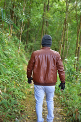 Travel and hiking along the forest path in autumn season - Young man walking in woods .