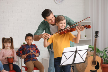 Teacher giving music lessons at school