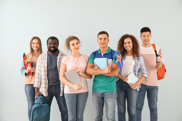 Obraz premium Young students of language school on color background