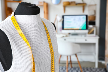 Mannequin with clothes and measuring tape in atelier