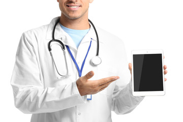 Young male doctor with tablet computer on white background