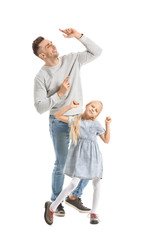 Man and his little daughter dancing against white background