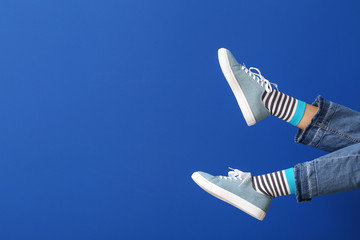 Legs of young woman on color background